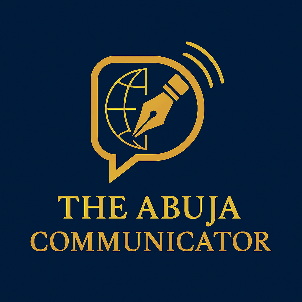 The image displays a gold logo on a dark navy background, featuring a speech bubble containing a globe and fountain pen nib, symbolising global communication and journalism, with the text "THE ABUJA COMMUNICATOR" elegantly written beneath it.